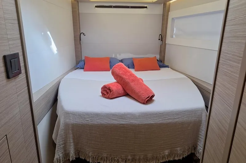 Yoff Yacht Photos Pics Luxurious cabin interior of 2023 Lagoon 46 yacht with cozy bed and vibrant decor.