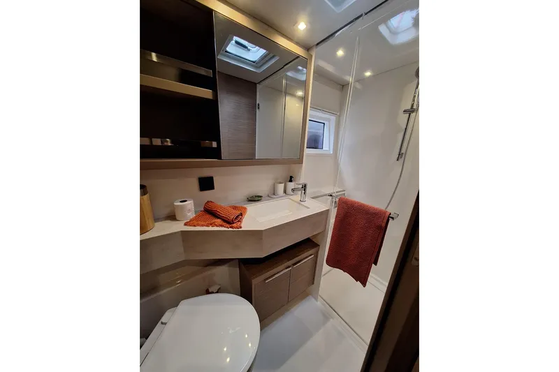 Yoff Yacht Photos Pics Modern bathroom in 2023 Lagoon 46 yacht with shower, sink, and storage.