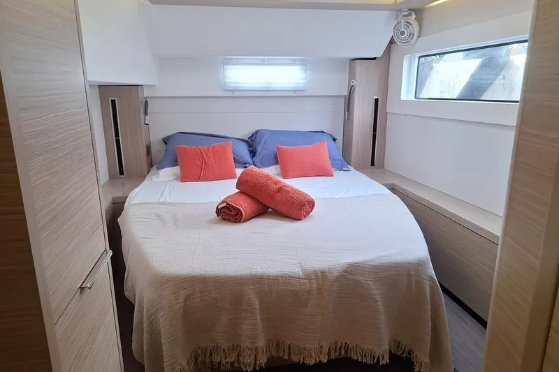 Yoff Yacht Photos Pics Luxurious bedroom interior of 2023 Lagoon 46 yacht with cozy bedding and modern design.