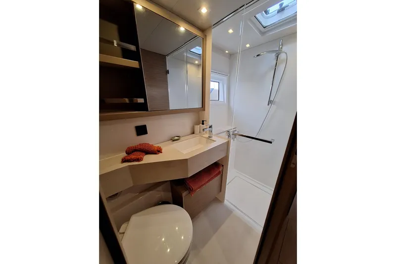 Yoff Yacht Photos Pics Modern bathroom in 2023 Lagoon 46 yacht with shower, sink, and toilet.