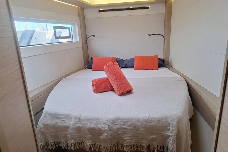 Yoff Yacht Photos Pics Luxurious cabin interior of 2023 Lagoon 46 yacht with cozy bed and vibrant decor.
