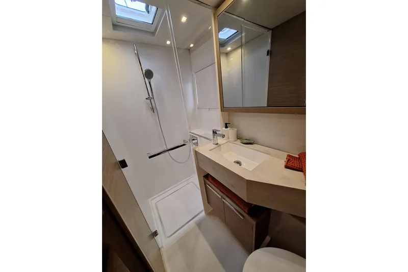 Yoff Yacht Photos Pics Modern bathroom in 2023 Lagoon 46 yacht with shower, sink, and mirror.