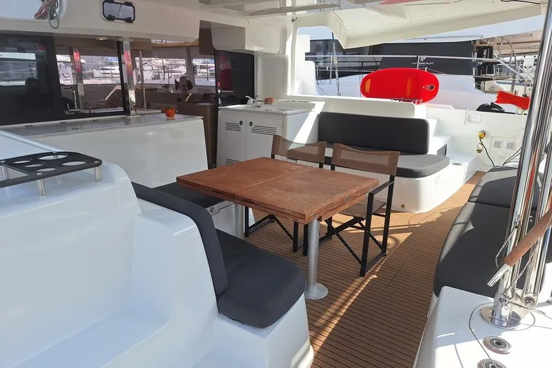Yoff Yacht Photos Pics Spacious interior of 2023 Lagoon 46 catamaran with seating and wooden table.