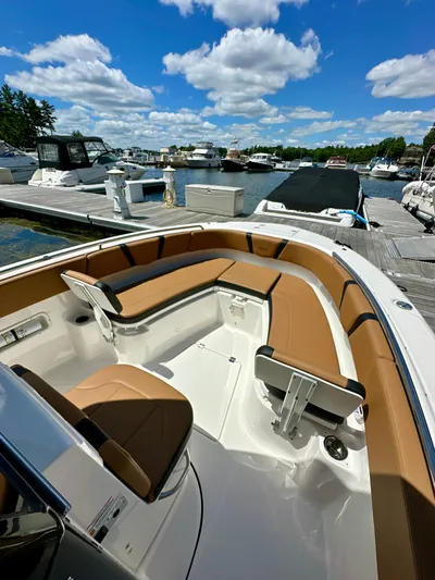  Yacht Photos Pics 2024 Robalo R250 Center Console boat with tan seating at a marina dock.