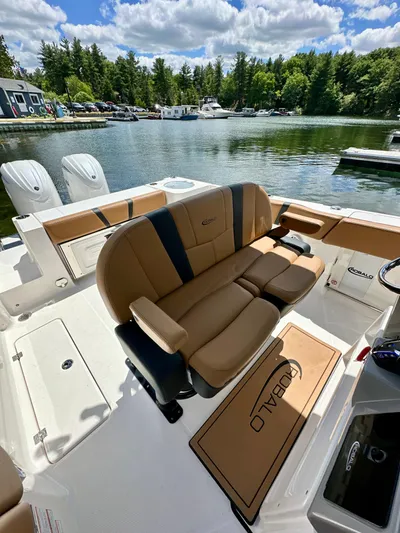  Yacht Photos Pics 2024 Robalo R250 Center Console boat with tan seating, docked by a scenic lake.