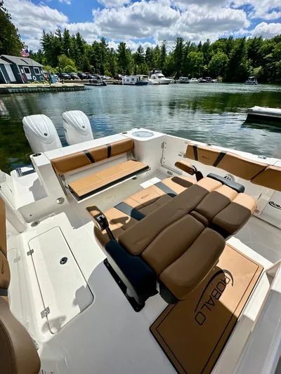  Yacht Photos Pics 2024 Robalo R250 Center Console boat interior with tan seating, docked by a scenic lake.