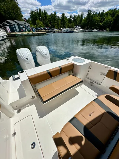 Yacht Photos Pics 2024 Robalo R250 Center Console boat with tan seating, docked by a scenic lake.