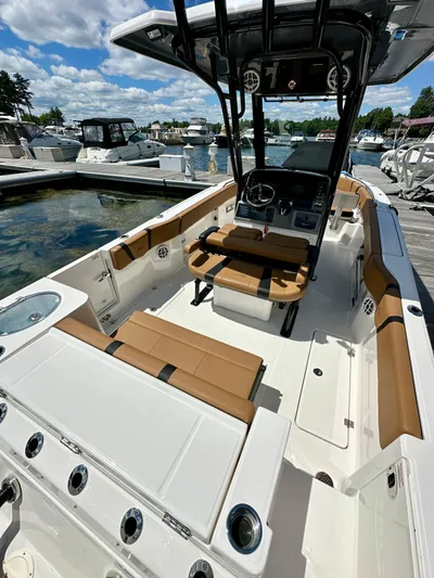  Yacht Photos Pics 2024 Robalo R250 Center Console boat with tan seating, docked at marina under blue sky.
