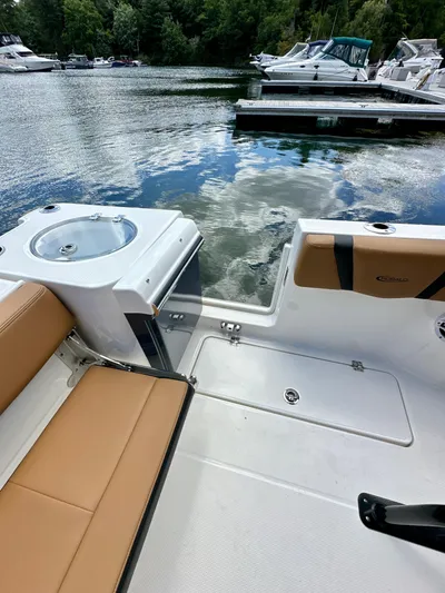  Yacht Photos Pics 2024 Robalo R250 Center Console boat interior with tan seating, docked on a calm lake.