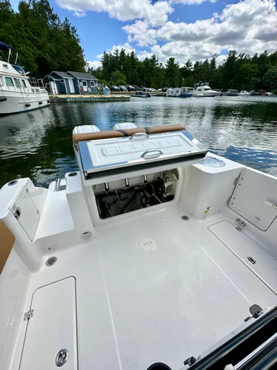  Yacht Photos Pics 2024 Robalo R250 Center Console boat docked on a serene lake.