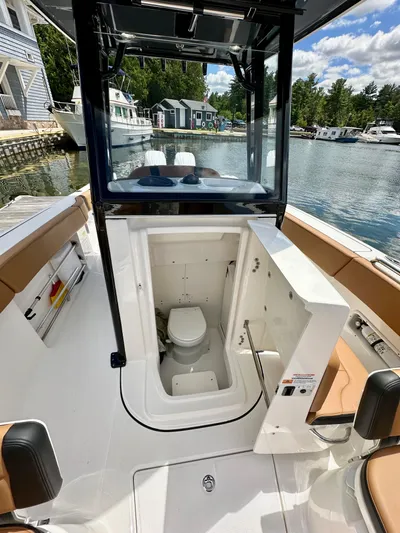  Yacht Photos Pics 2024 Robalo R250 Center Console boat with open console door revealing interior toilet.