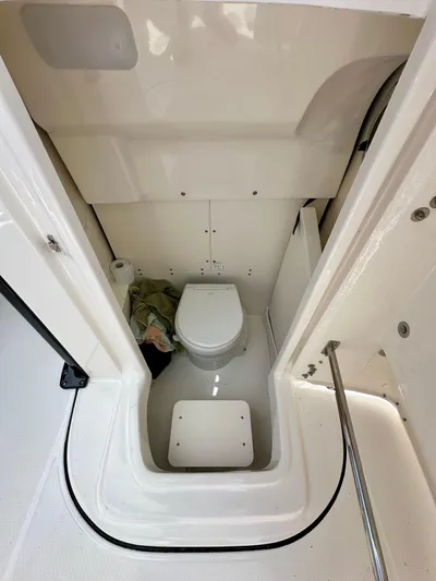  Yacht Photos Pics 2024 Robalo R250 Center Console boat interior with compact marine toilet.