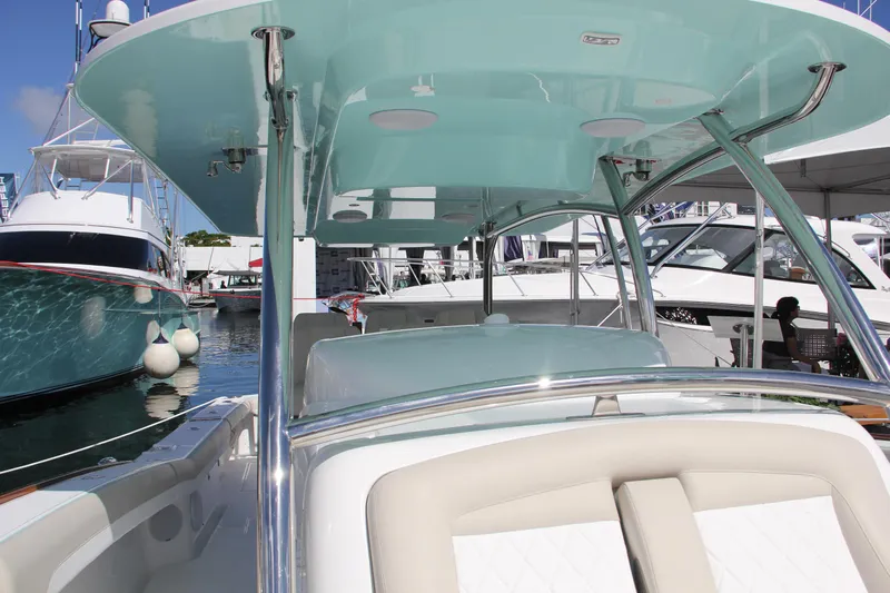  Yacht Photos Pics 2025 Mag Bay 43 boat interior at marina, showcasing helm and seating area.