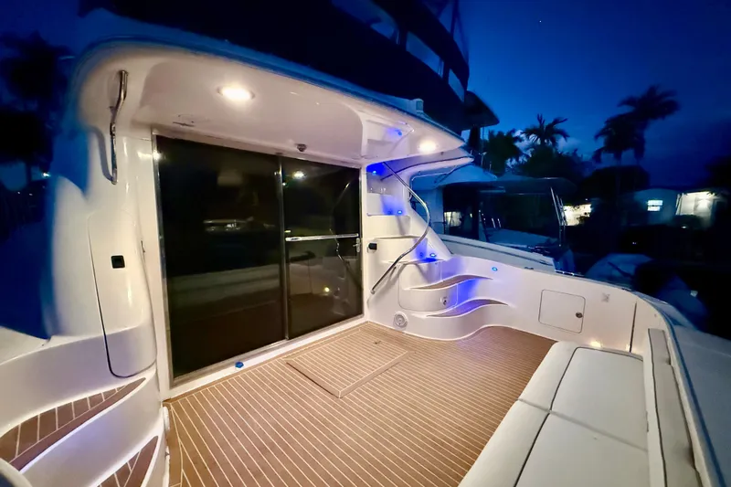  Yacht Photos Pics 1999 Sea Ray 560 Sedan Bridge yacht deck illuminated at night, featuring sleek design and ambient lighting.