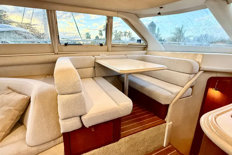  Yacht Photos Pics Interior of 1999 Sea Ray 560 Sedan Bridge with cozy dining area and scenic window view.