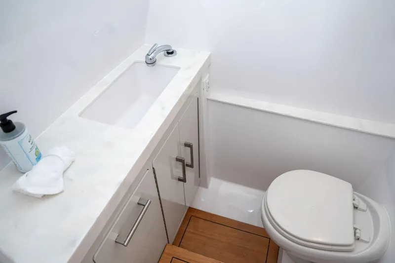  Yacht Photos Pics Modern bathroom in 2022 Jupiter 32 boat with sink, toilet, and wooden flooring.
