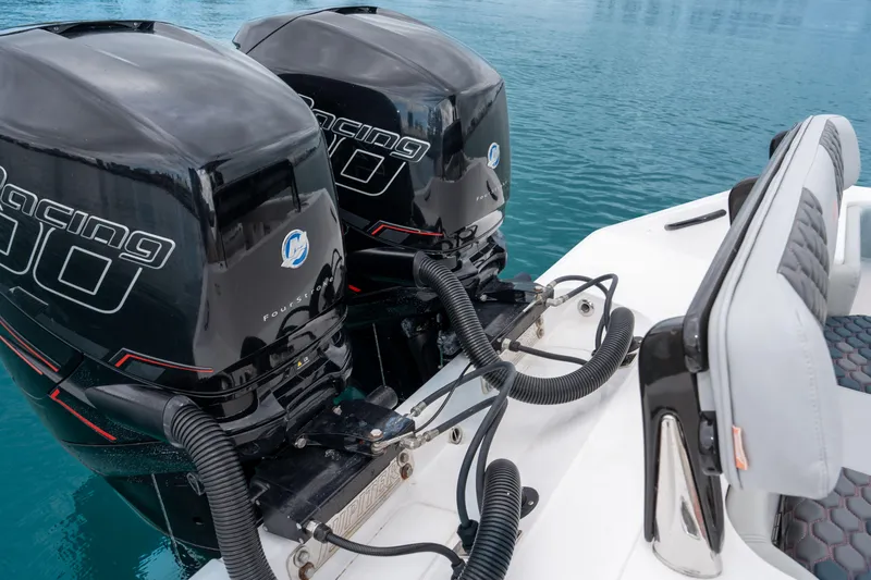  Yacht Photos Pics Twin outboard engines on a 2022 Jupiter 32 boat, docked on calm blue water.