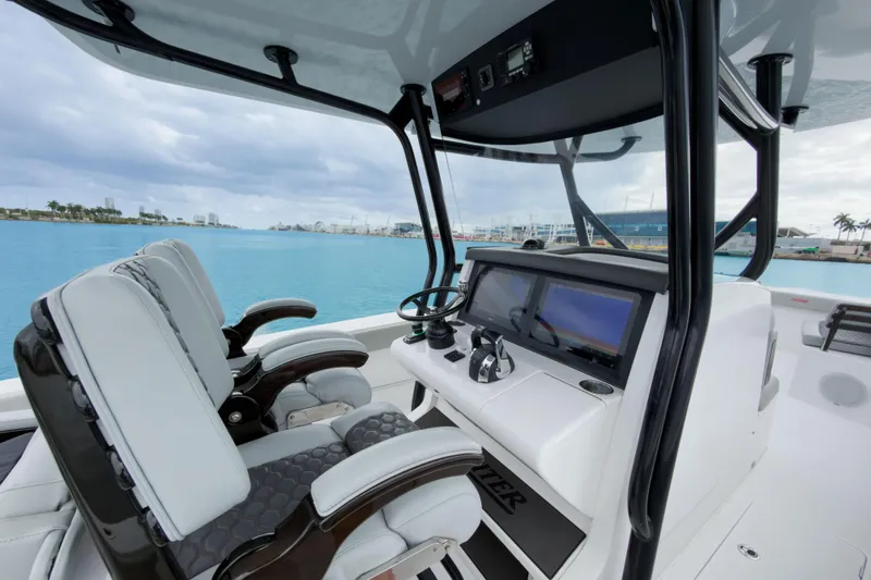  Yacht Photos Pics 2022 Jupiter 32 boat cockpit with modern controls and dual seating, overlooking a marina.