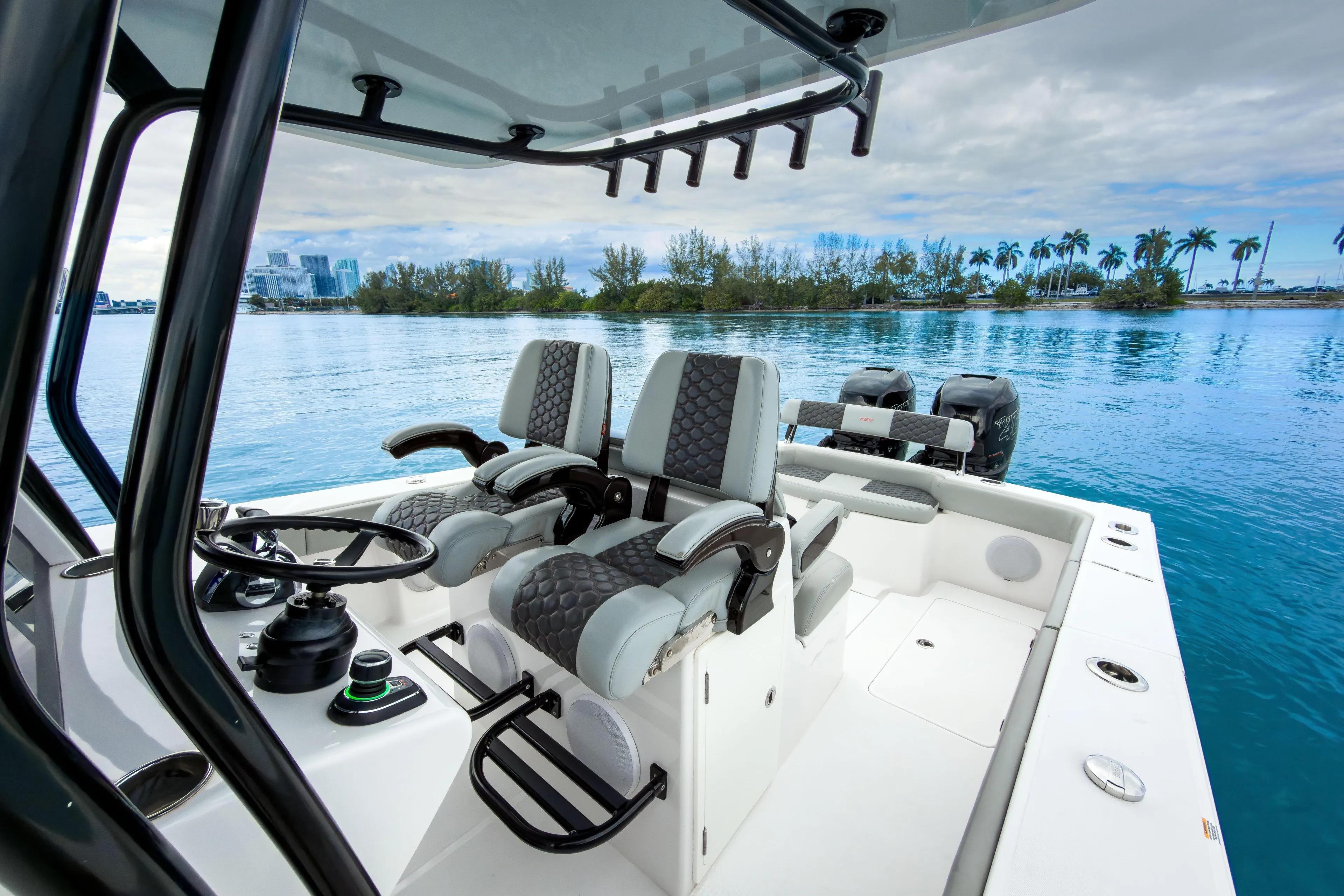  Yacht Photos Pics 2022 Jupiter 32 boat interior with dual seats, steering wheel, and scenic waterfront view.