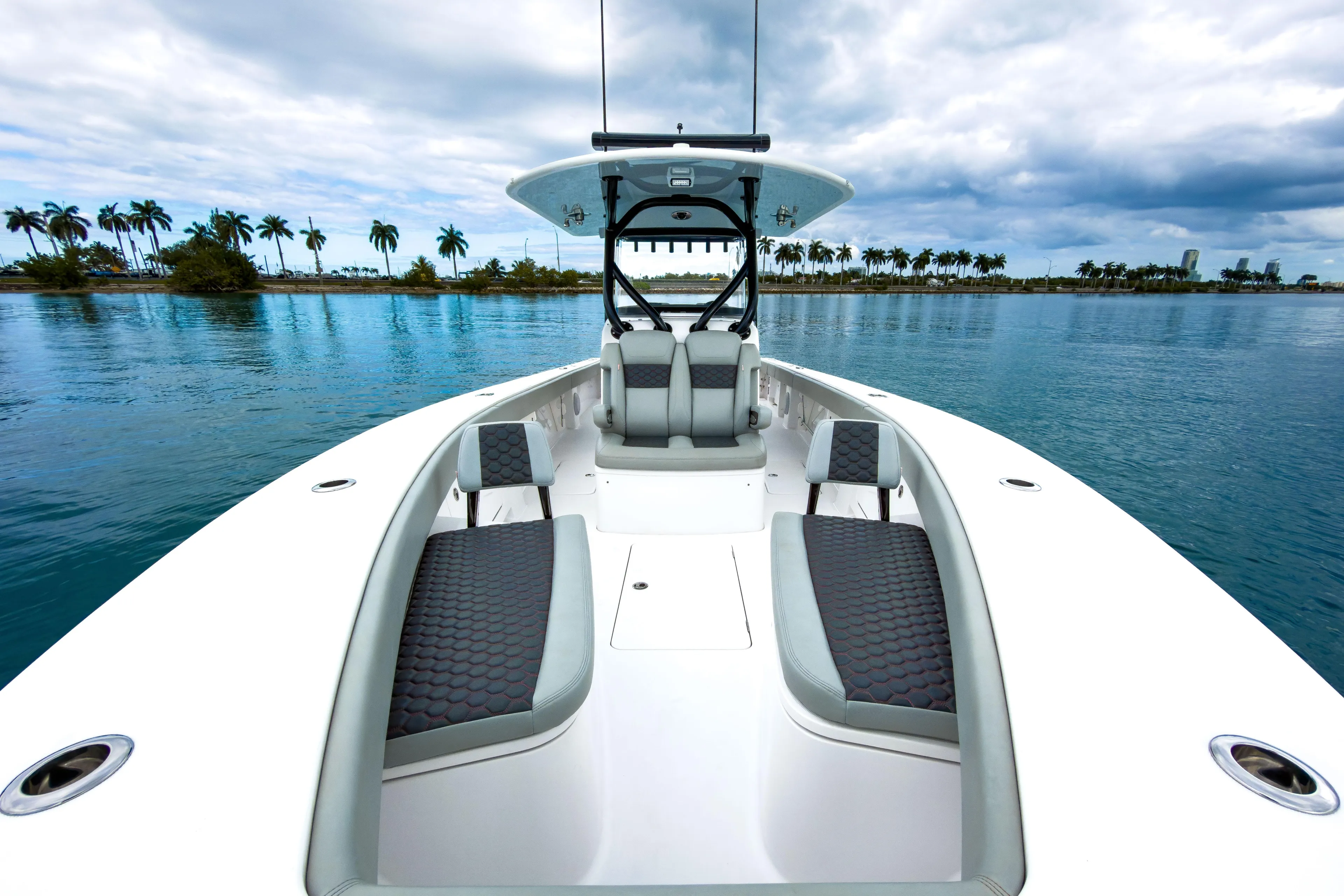  Yacht Photos Pics 2022 Jupiter 32 boat on calm water with palm trees in the background.