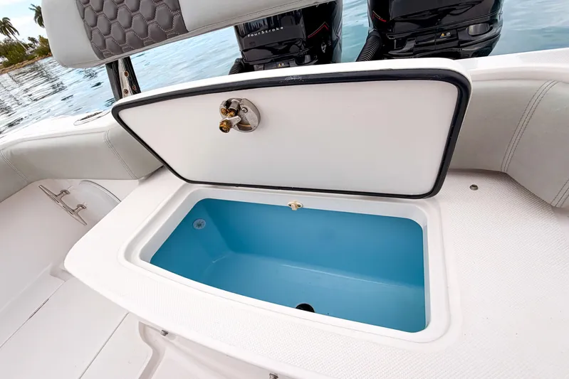  Yacht Photos Pics Open storage compartment on 2022 Jupiter 32 boat with dual engines in background.