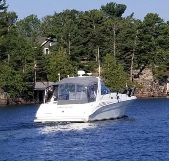  Yacht Photos Pics 1997 Sea Ray 400 Sundancer cruising on a lake with forested shoreline.