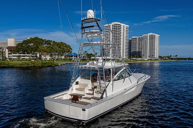  Yacht Photos Pics 2023 Viking 54 Open yacht cruising near waterfront skyscrapers.