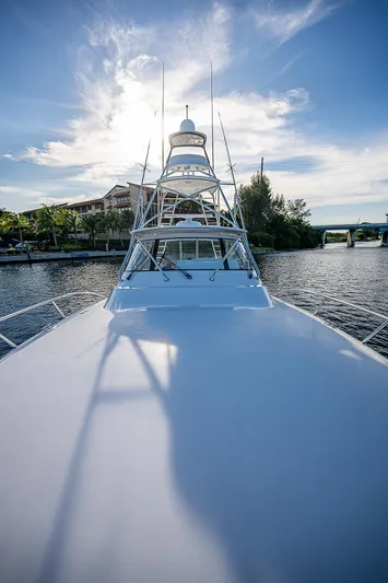  Yacht Photos Pics 2023 Viking 54 Open yacht on a serene river under a blue sky.