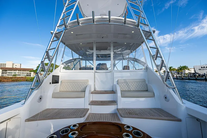  Yacht Photos Pics 2023 Viking 54 Open yacht with spacious deck and seating, docked by the water.