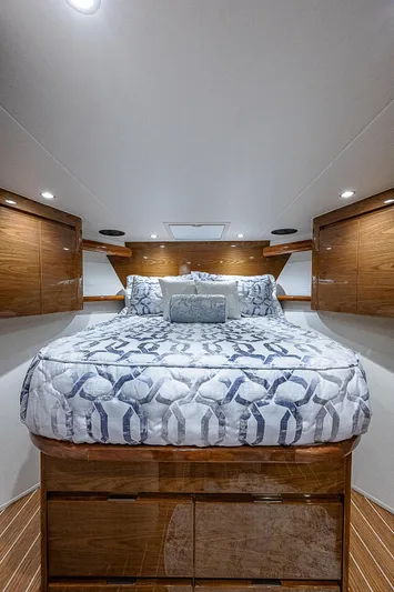  Yacht Photos Pics Luxurious bedroom interior of 2023 Viking 54 Open yacht with elegant bedding and wood accents.