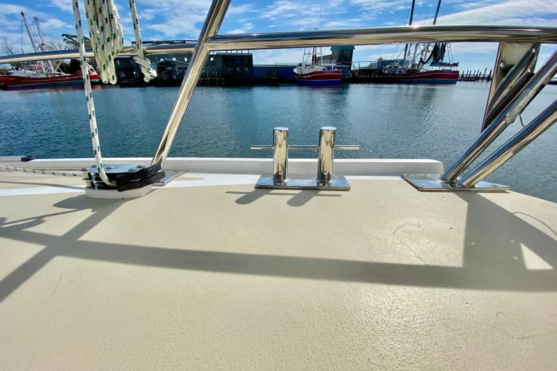 Wonder Yacht Photos Pics Boat deck view with metal railings, docked ships, and clear blue sky. Wellington 44, 1980.