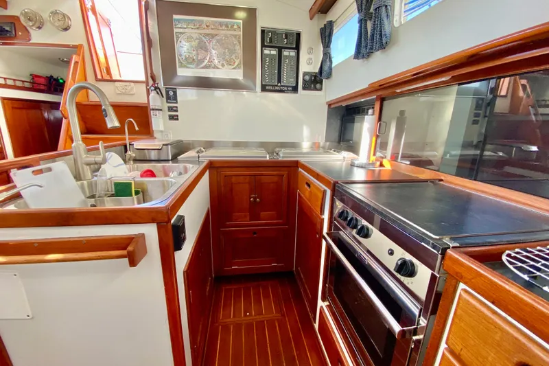 Wonder Yacht Photos Pics Galley kitchen in 1980 Wellington 44 yacht with wood cabinetry and modern appliances.