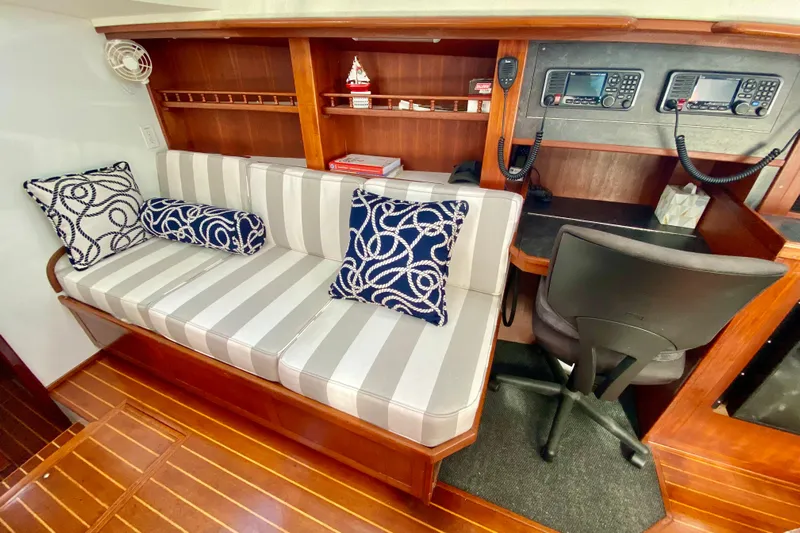 Wonder Yacht Photos Pics Cozy interior of 1980 Wellington 44 yacht with striped seating and navigation equipment.