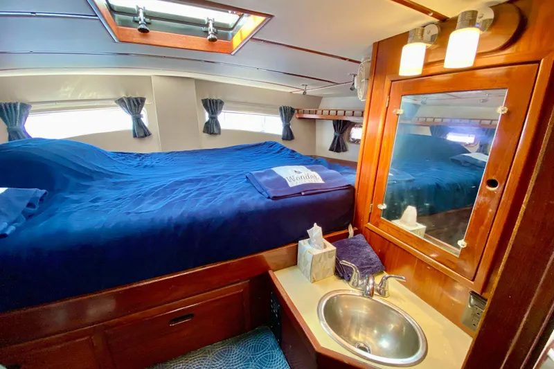 Wonder Yacht Photos Pics Cozy 1980 Wellington 44 yacht cabin with bed, sink, and mirror.