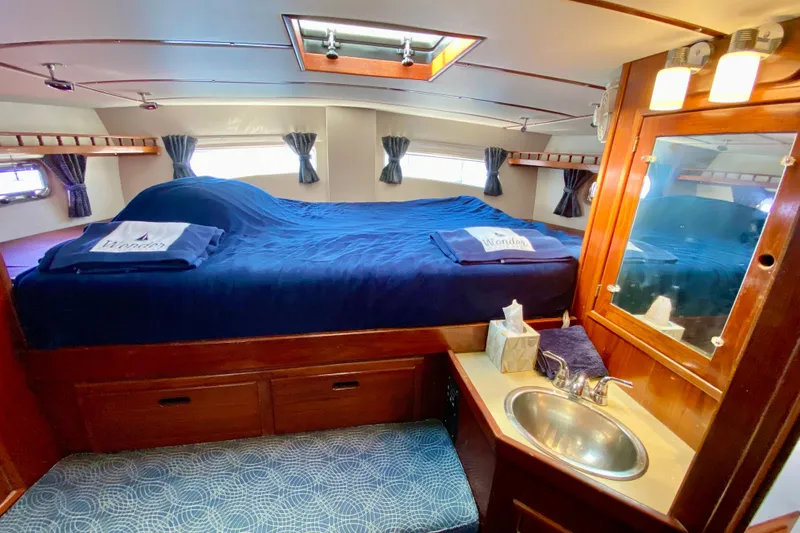 Wonder Yacht Photos Pics Cozy 1980 Wellington 44 yacht cabin with bed, sink, and wooden cabinetry.