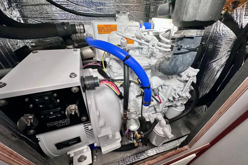 Wonder Yacht Photos Pics Engine compartment of a 1980 Wellington 44, featuring a Phasor generator and blue hoses.
