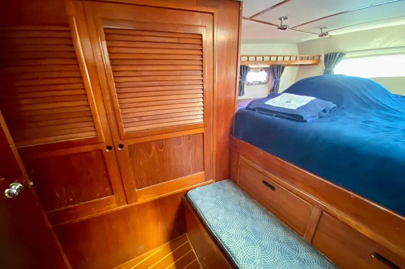 Wonder Yacht Photos Pics Cozy cabin interior of 1980 Wellington 44 yacht with wooden furnishings and blue bedding.