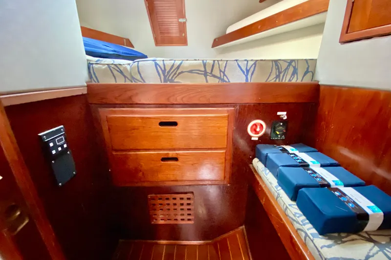 Wonder Yacht Photos Pics Cozy cabin interior of 1980 Wellington 44 yacht with wooden drawers and bedding.