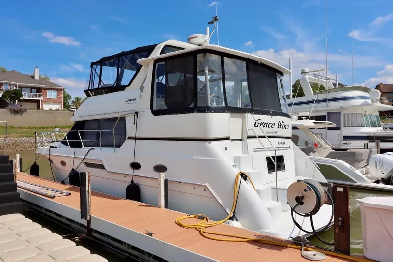 Grace Wins II Yacht Photos Pics 2001 Carver 406 Motor Yacht docked at marina under clear blue sky.