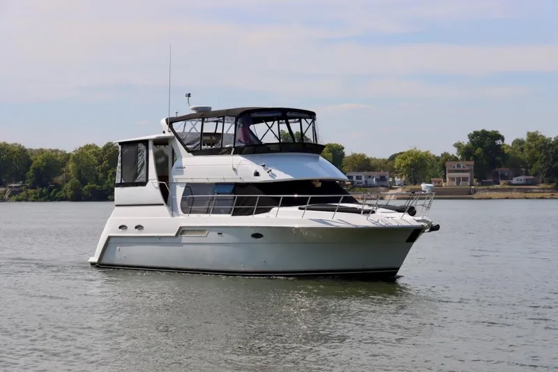 Grace Wins II Yacht Photos Pics 2001 Carver 406 Motor Yacht cruising on a calm river with scenic background.