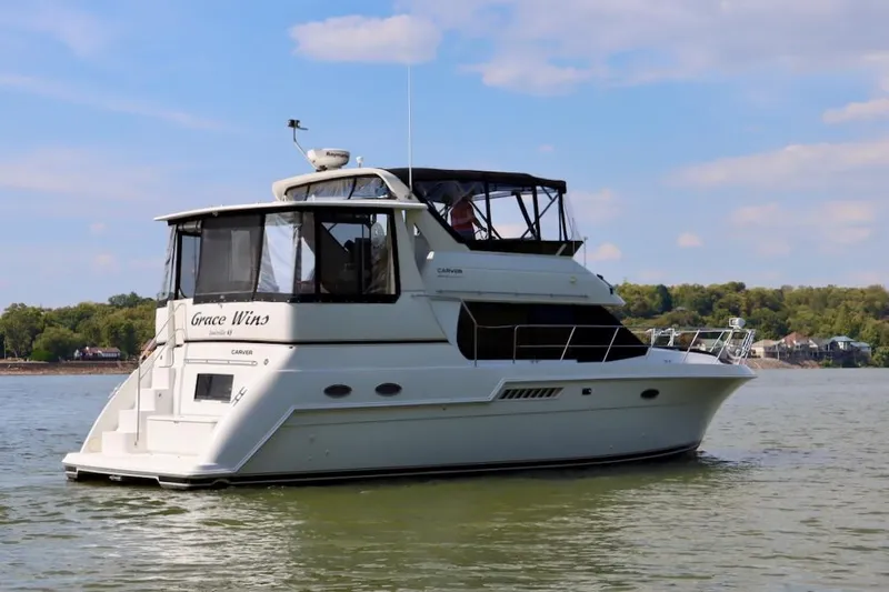 Grace Wins II Yacht Photos Pics 2001 Carver 406 Motor Yacht on calm water, featuring elegant design and spacious deck.