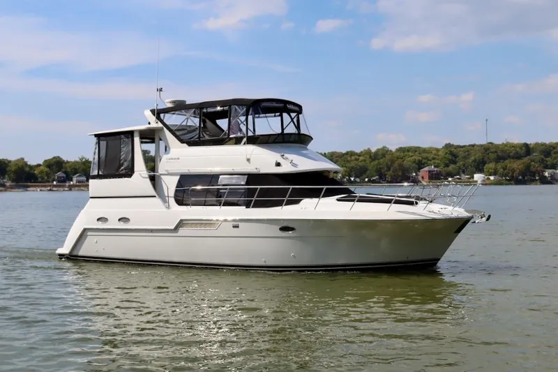 Grace Wins II Yacht Photos Pics 2001 Carver 406 Motor Yacht cruising on a calm lake under a clear sky.