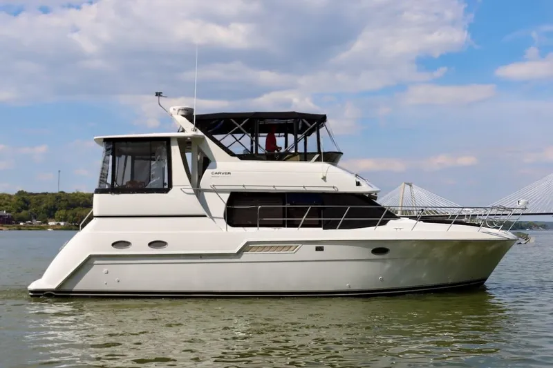 Grace Wins II Yacht Photos Pics 2001 Carver 406 Motor Yacht on calm water under a partly cloudy sky.