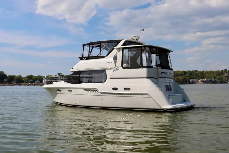 Grace Wins II Yacht Photos Pics 2001 Carver 406 Motor Yacht on calm water under a partly cloudy sky.