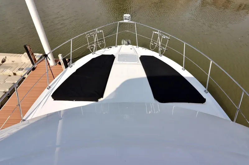 Grace Wins II Yacht Photos Pics 2001 Carver 406 Motor Yacht bow view at dock, featuring sun pads and railing.