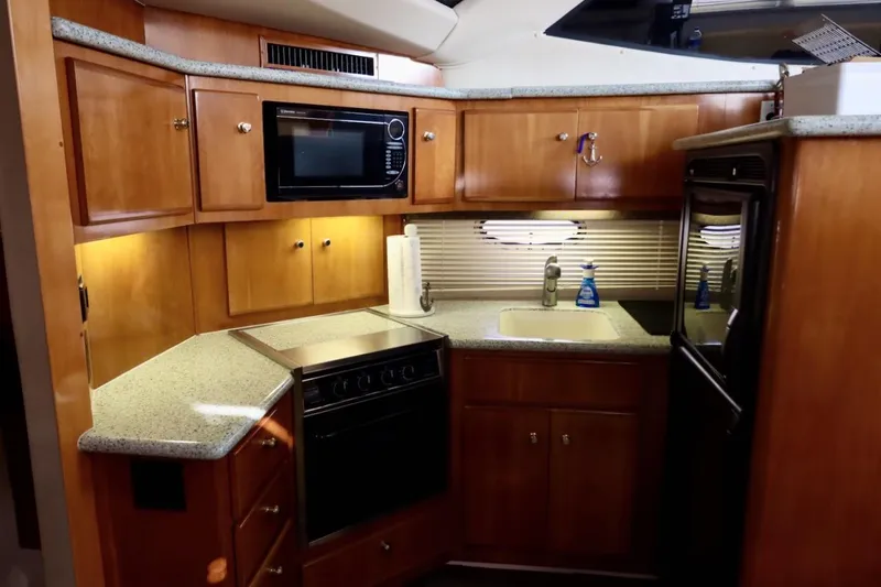 Grace Wins II Yacht Photos Pics 2001 Carver 406 Motor Yacht kitchen with wooden cabinets and modern appliances.