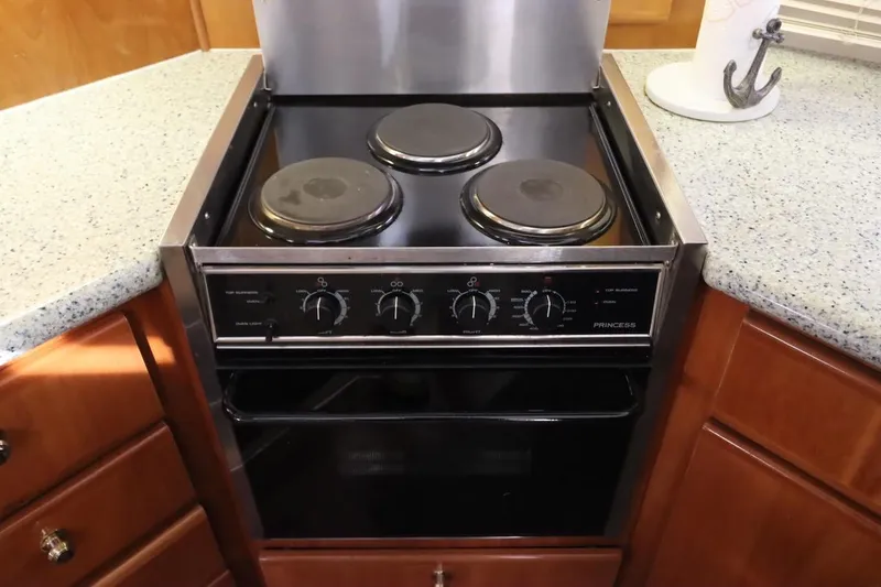 Grace Wins II Yacht Photos Pics Electric stove in a 2001 Carver 406 Motor Yacht kitchen, featuring three burners and control knobs.