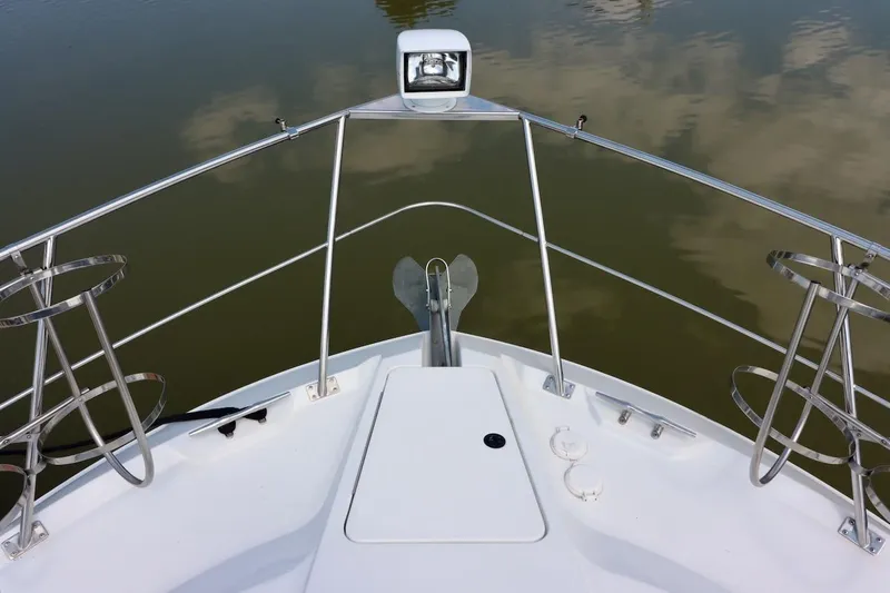 Grace Wins II Yacht Photos Pics Bow view of 2001 Carver 406 Motor Yacht with anchor and railing over calm water.