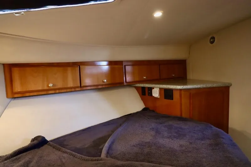 Grace Wins II Yacht Photos Pics Interior cabin of 2001 Carver 406 Motor Yacht with wooden cabinets and cozy bedding.