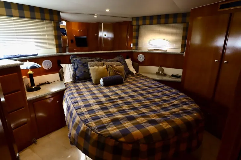 Grace Wins II Yacht Photos Pics Luxurious bedroom interior of 2001 Carver 406 Motor Yacht with plaid bedding and wood accents.